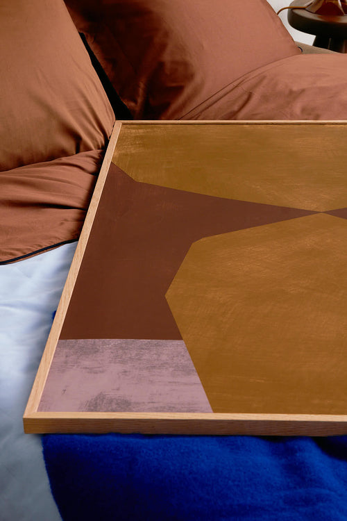 Abstract art piece with geometric shapes on a bed