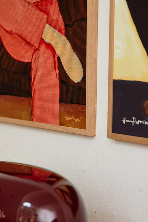 Framed artwork on a wall with a close-up of a red and yellow abstract painting.
