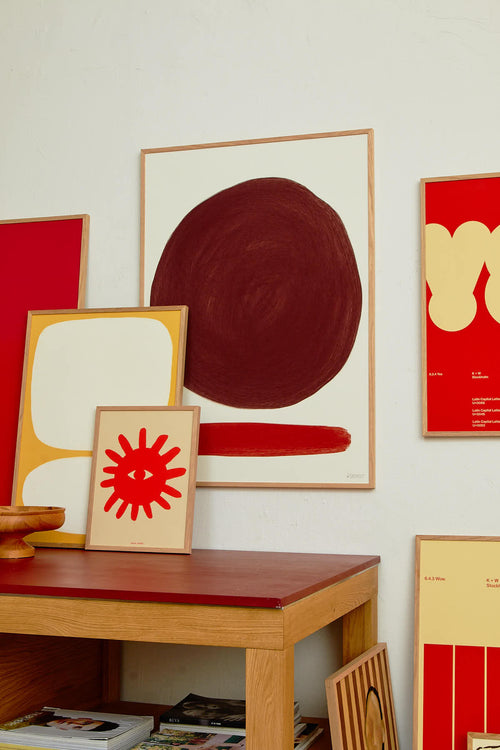Abstract art pieces on a wall with a wooden table in the foreground
