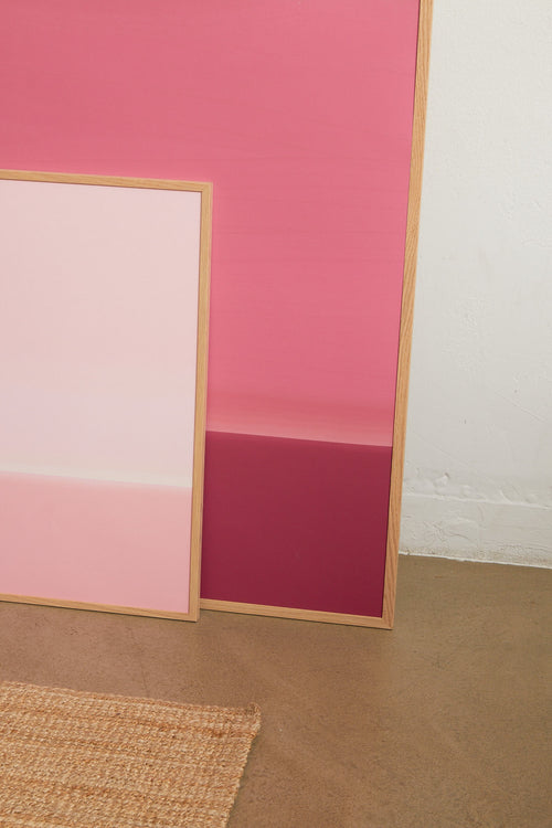 Art print with an abstract spray painting of a sky in deep pink-lilac tones. Styled in a minimalist interior.