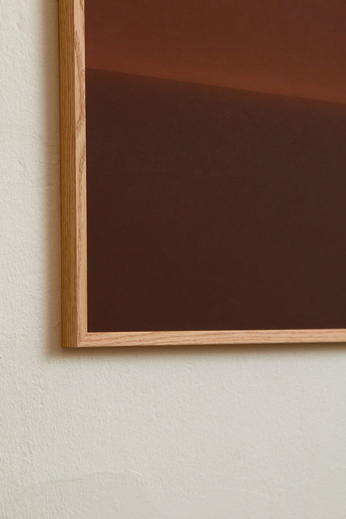 Art print with an abstract spray painting of a dark sky in deep brown tones. Styled in a minimalist interior.