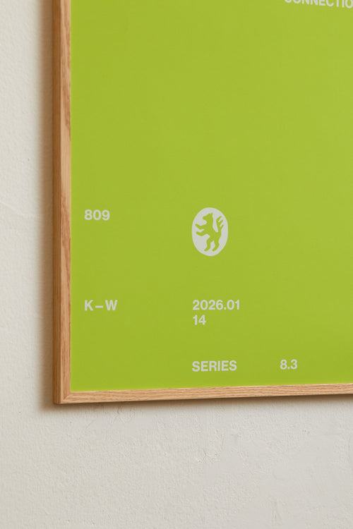 Art print with minimalist, small graphic text elements and a symbol motif in white against a lime green background. Styled in a minimalist interior.