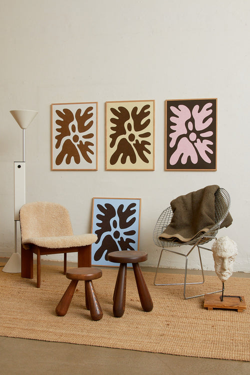Art print featuring a minimalistic motif in warm brown and soft beige, with shapes that explore the space between abstraction and recognition through soft, fluid forms. Styled in a minimalist interior.
