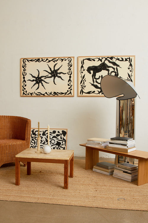 Art print with a minimalist illustration of black, organic, hand-drawn lines and suns against an off-white background. Styled in a minimalist interior.