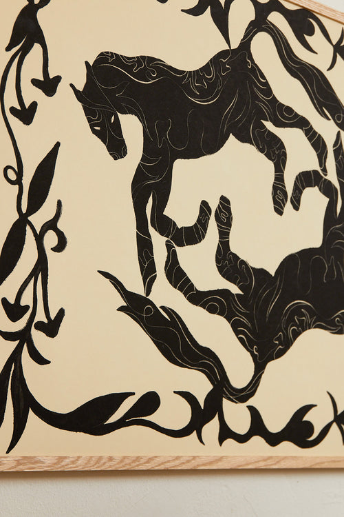 Art print with a minimalist illustration of black, organic, hand-drawn lines and silhouettes of horses against an off-white background. Styled in a minimalist interior.