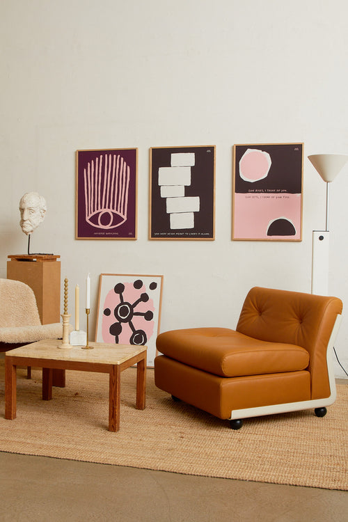 Art print with an abstract, minimalist painting in brown and pink that references a sunrise and a sunset. Styled in a minimalist interior.