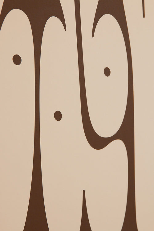 Art print featuring playful, bold typography of the word “Baby” in sand beige against a dark brown background. Styled in a minimalist interior.