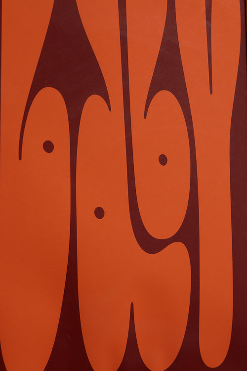 Art print featuring playful, bold typography of the word “Baby” in rust orange against a dark brown background. Styled in a minimalist interior.