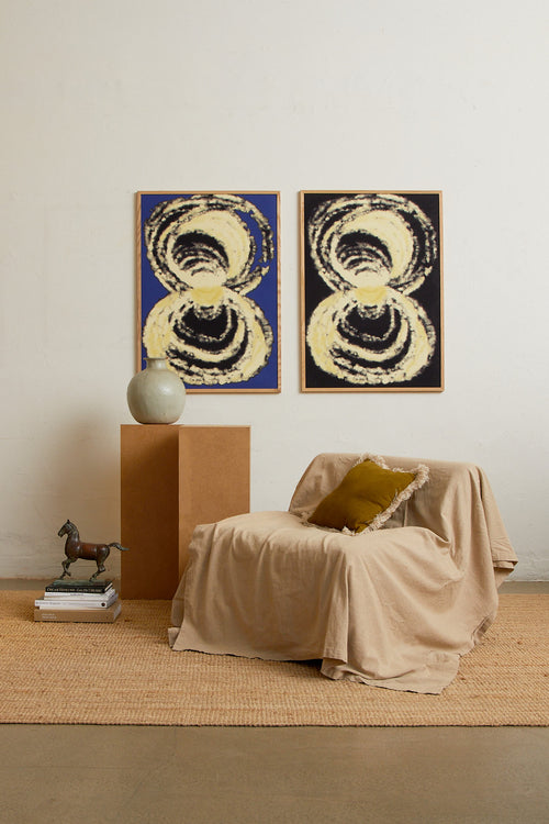Art print with an abstract illustration of circular forms in light tones against a cobalt blue background, with a soft and organic expression. Styled in a minimalist interior.