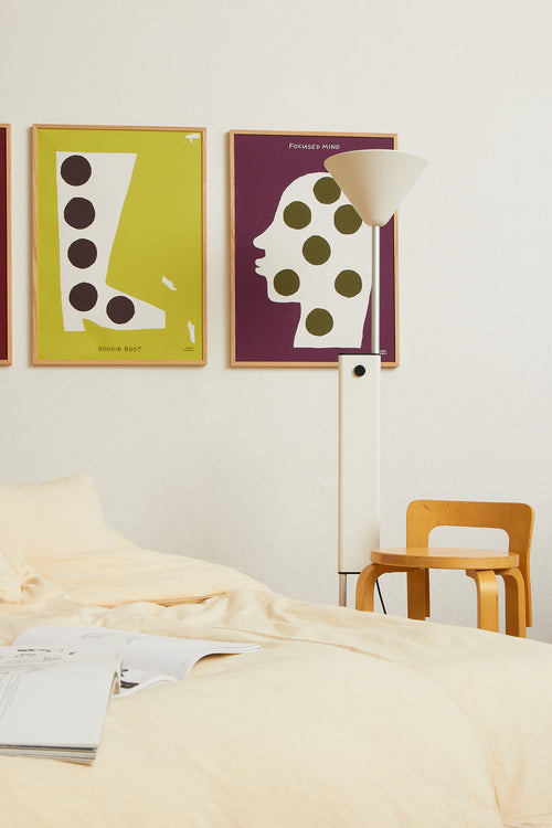 Interior scene with the olive green print displayed alongside other colorful artworks on a wall