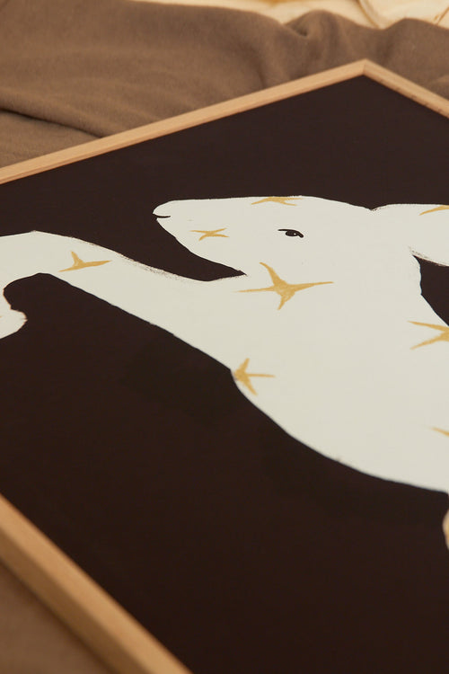 Art print with a stylized illustration of a hare in a light tone with stars against a dark brown background, with a minimalist and graphic expression. Styled in a minimalist interior.