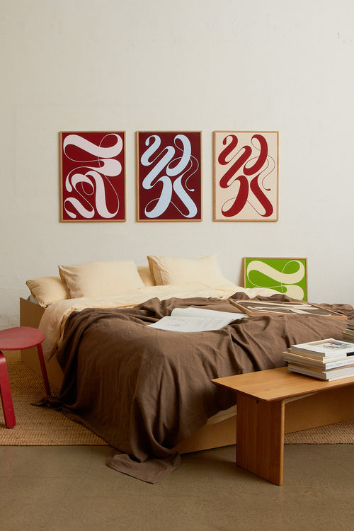 Art print featuring exploratory organic forms emerging in beige and red. Styled in a minimalist interior.