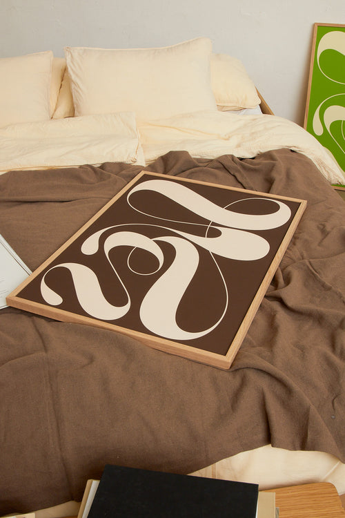 Art print featuring exploratory organic forms emerging in brown and sand beige. Styled in a minimalist interior.
