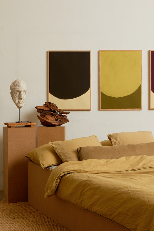 Art print with a minimalist illustration of a large, rounded color field in a dark brown tone against a light beige background. Styled in a minimalist interior.