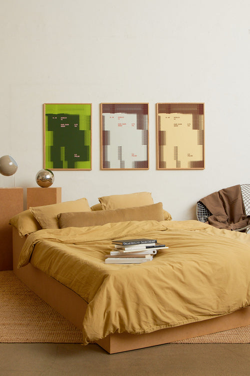 Art print with a graphic illustration of rectangular fields and linear patterns, combined with small text elements, in green and pink RAL colors. Styled in a minimalist interior.