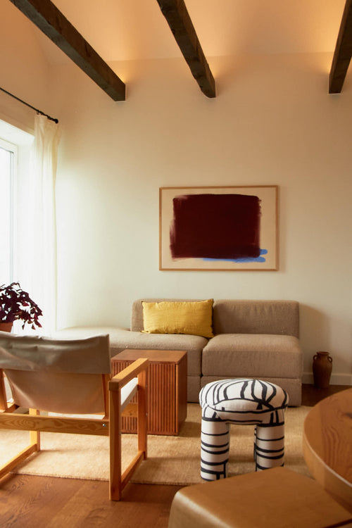 Living room with a gray sofa, wooden coffee table, and abstract painting on the wall.