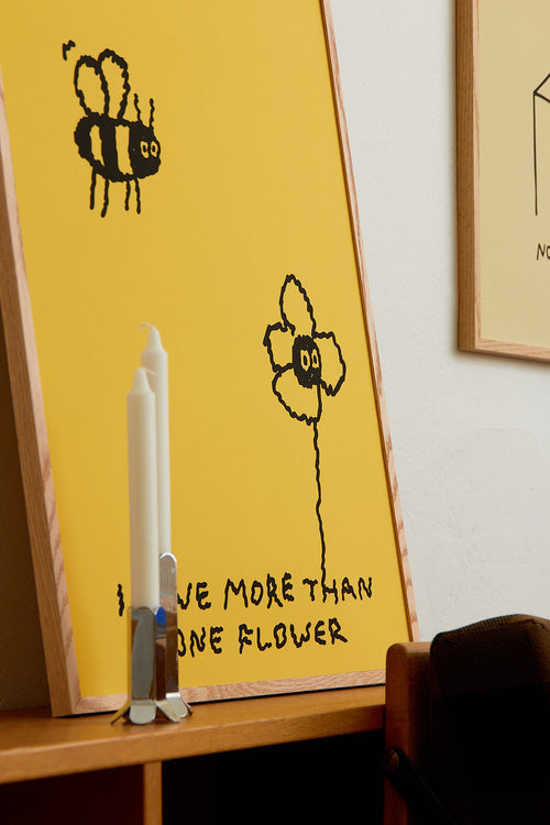 Yellow board with a bee and flower drawing and text 