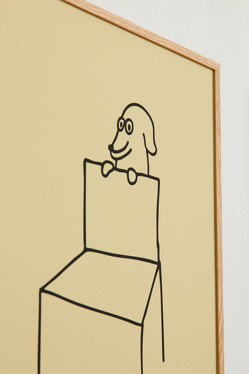 Framed artwork of a minimalist line drawing of a dog on a chair against a beige background