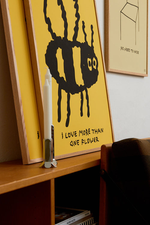 Yellow poster with black graphic and text on a shelf