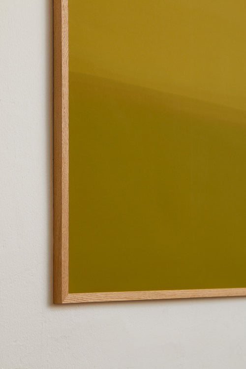 Framed green artwork on a white wall