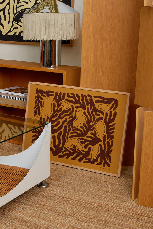 Decorative wall art with abstract design on a wooden frame, placed on a textured surface.