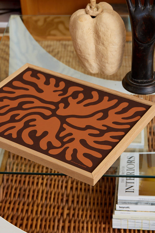 Decorative wooden box with coral pattern on a glass table