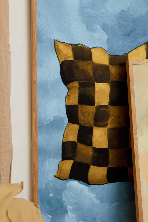 Checkered pillow with brown and black pattern on a blue background
