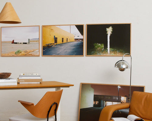 Modern interior with framed artworks on the wall, a table, and chairs.