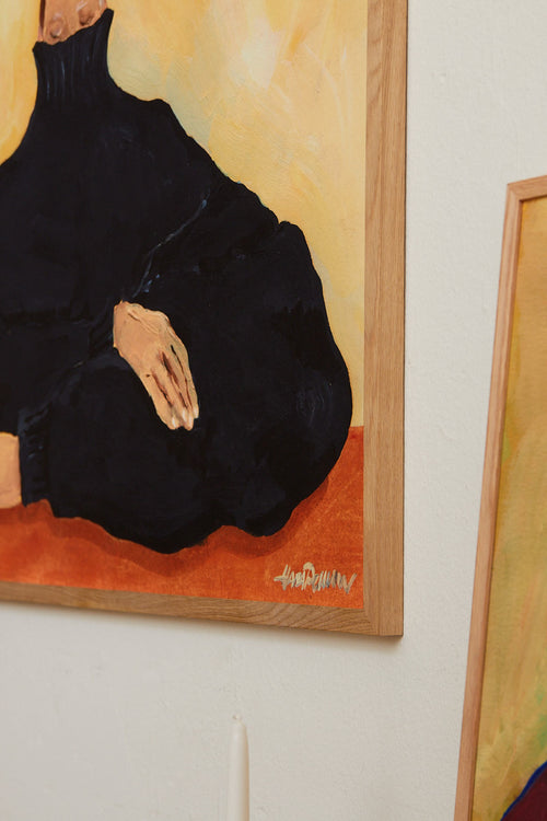 Framed painting of a person in a black outfit on a beige wall