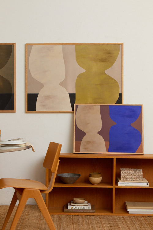 Modern interior with abstract art on the wall and a wooden shelf.