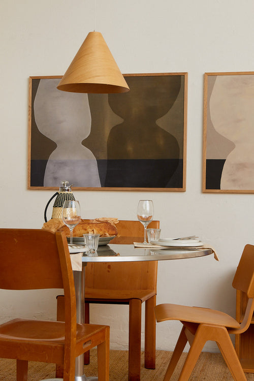 Dining room with wooden chairs, round table, and abstract art on the wall.
