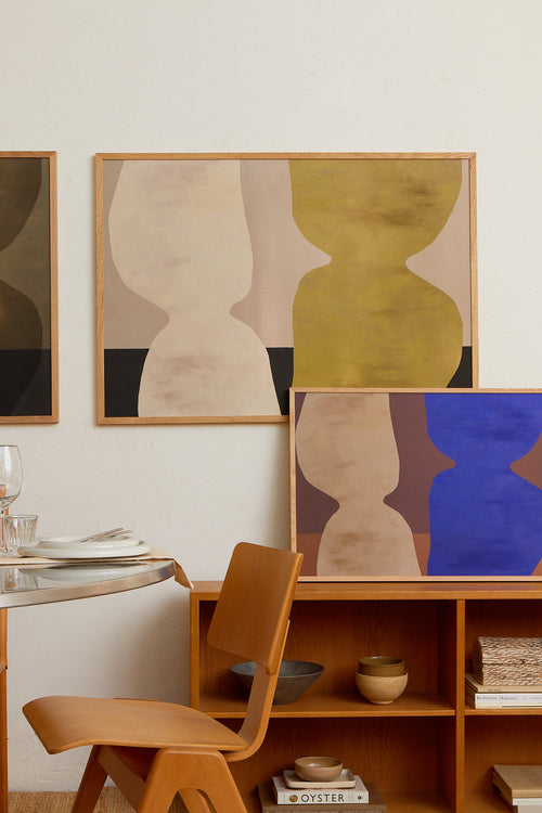 Dining area with abstract art on the wall and wooden furniture.