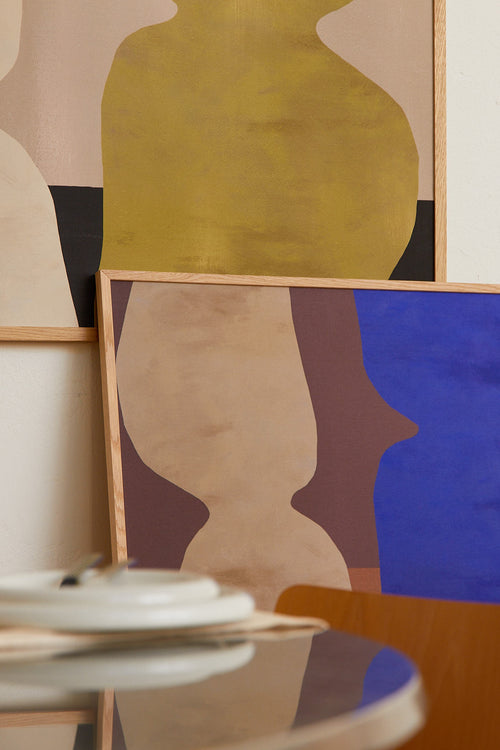 Abstract art pieces on a wall with a table in the foreground