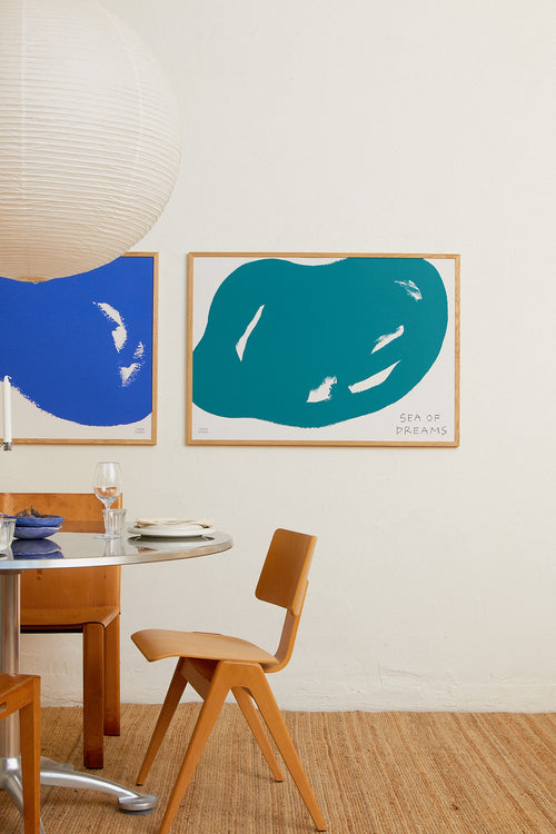 Dining room with wooden table and chairs, and abstract art on the wall.