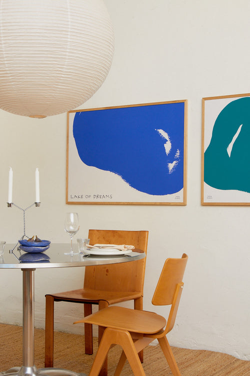 Dining area with wooden chairs, a table, and abstract art on the wall.