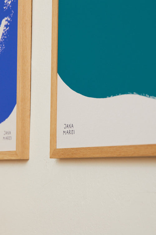 Two framed artworks by Jana Marei on a light beige wall.