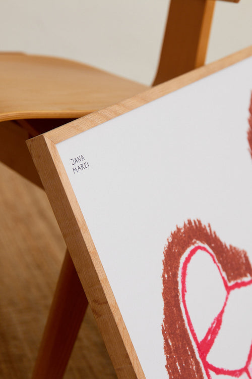 Framed artwork with a red abstract design on a wooden easel