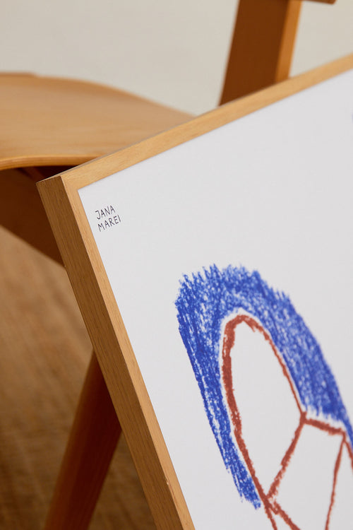 Framed artwork with a blue and red abstract design on a wooden easel.