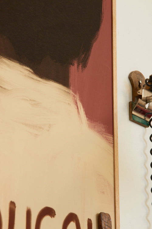 Close-up of a person wearing a beige shirt with text, framed by a white border.