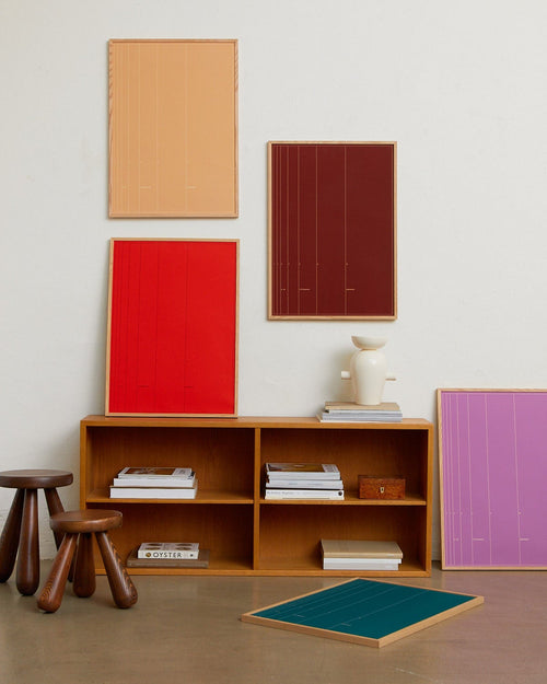 Modern interior with wooden shelf, colorful panels on the wall, and a small table.