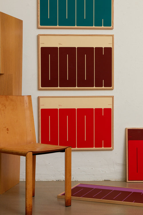 Wooden chair and colorful abstract artworks on a white wall