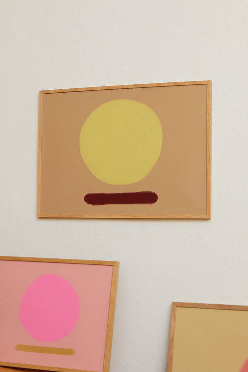 Abstract art pieces with colorful circles on a wall.