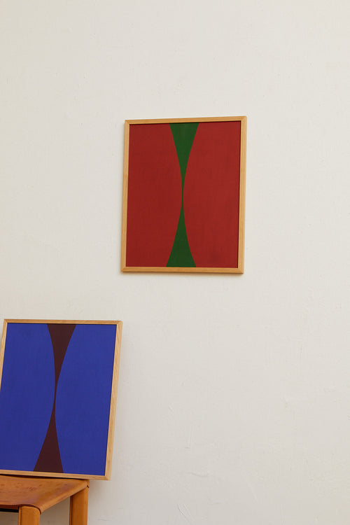 Abstract art pieces on a wall with a red and green painting and a blue and purple painting.