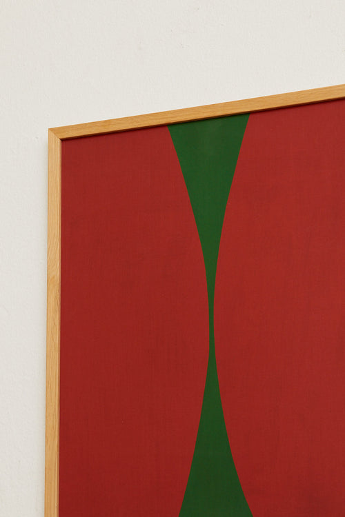 Abstract art piece with red and green shapes on a white wall