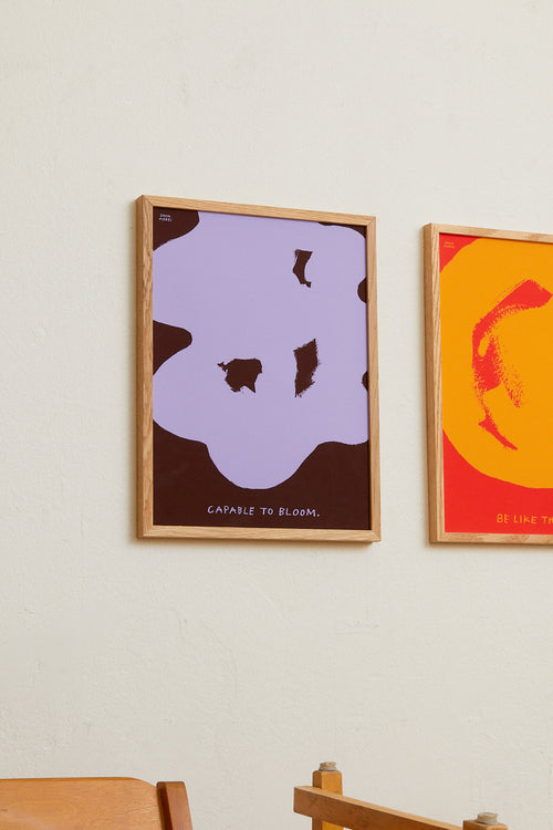 Two framed abstract artworks on a wall with text.