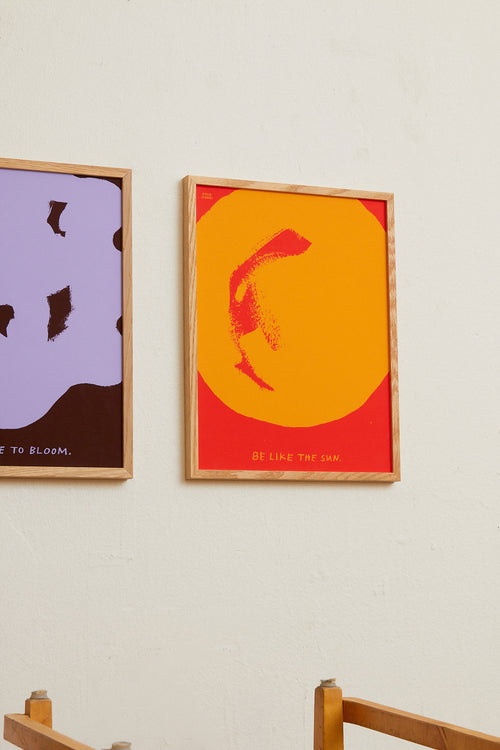 Two framed abstract artworks on a wall with wooden frames.