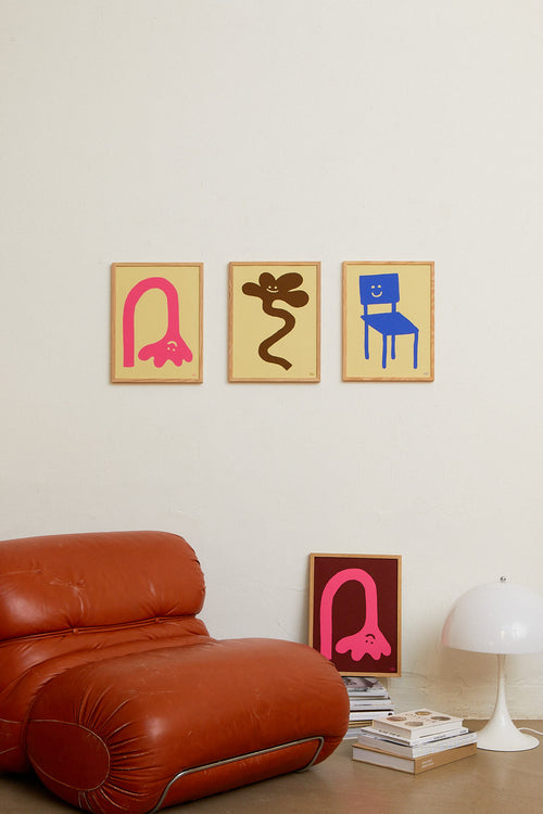 Modern living room with a red sofa, abstract wall art, and a lamp.