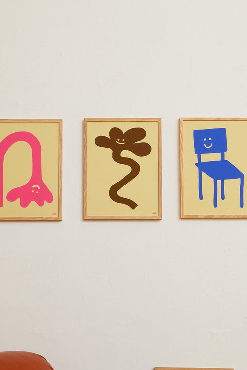 Three abstract artworks in gold frames on a white wall.