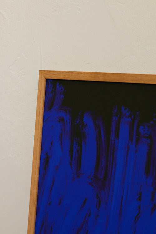 Framed artwork with blue abstract design on a beige wall