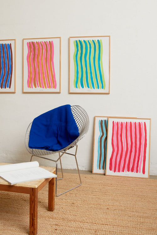 Interior scene with multiple colorful striped art prints on a light wall.